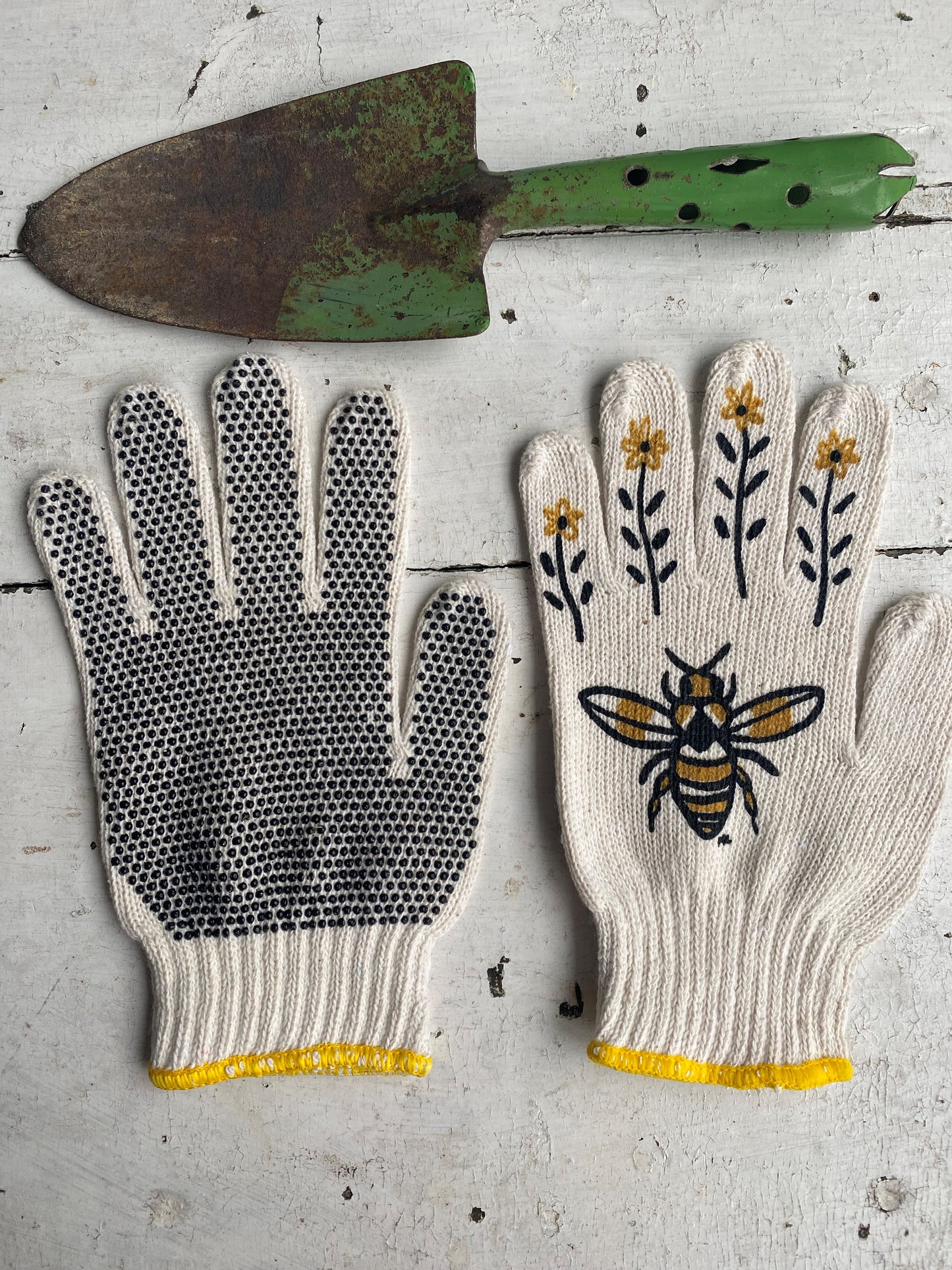 hand painted bee gardening gloves with a vintage green shovel as a prop