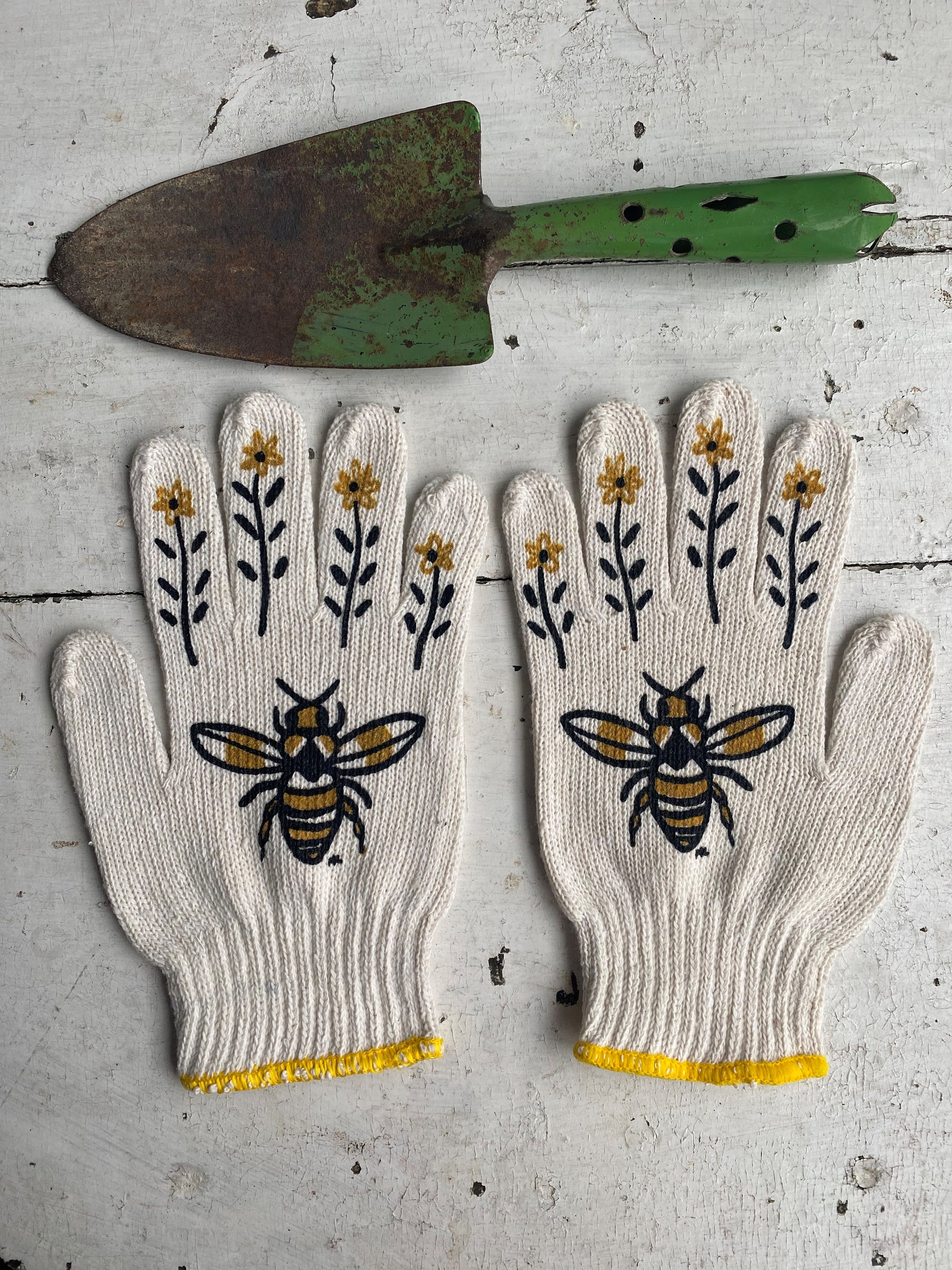 hand painted bee gardening gloves with a vintage green shovel as a prop