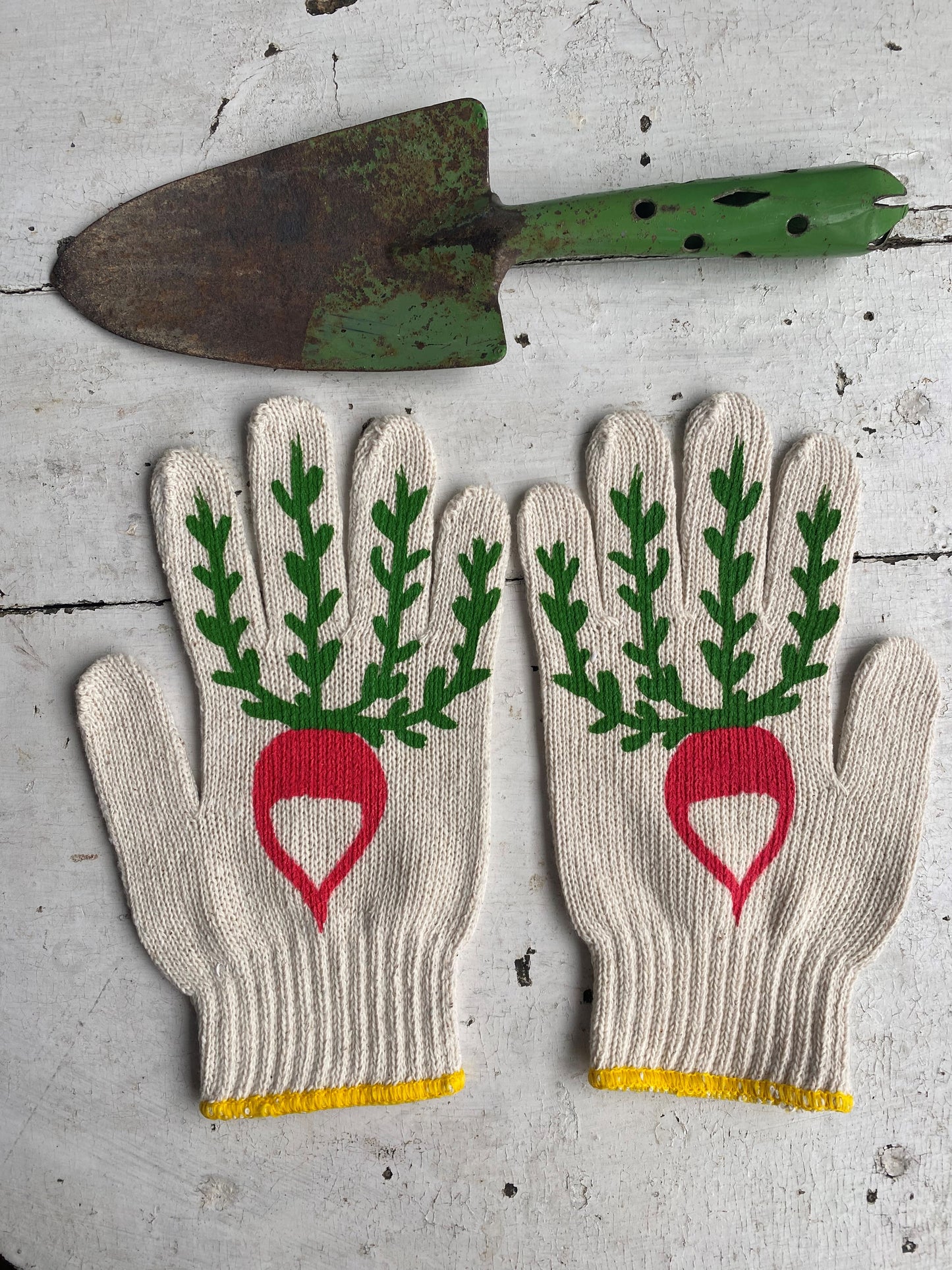 hand painted radish gardening gloves with a vintage green shovel as a prop